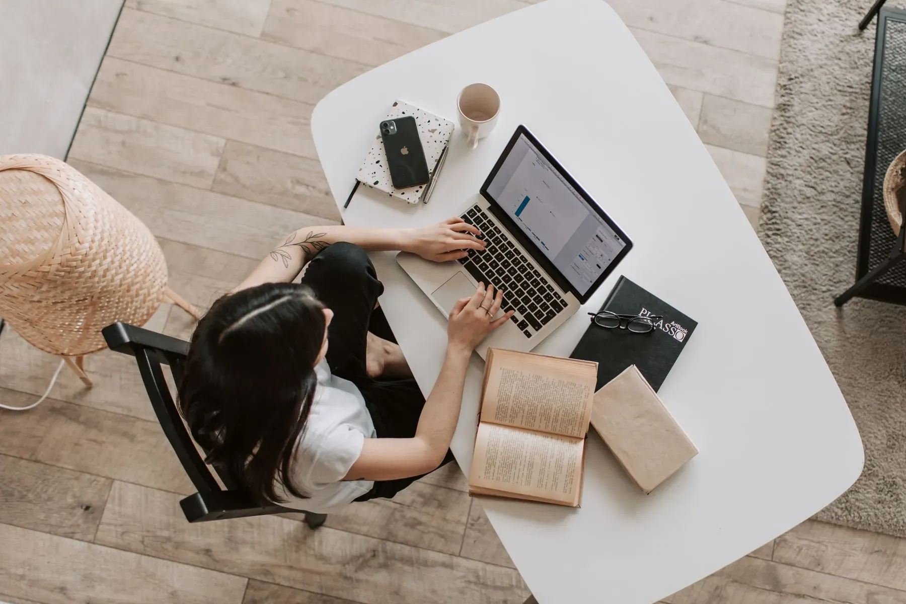 Arbeitsplatz von oben mit Laptop, Buch und Kaffee